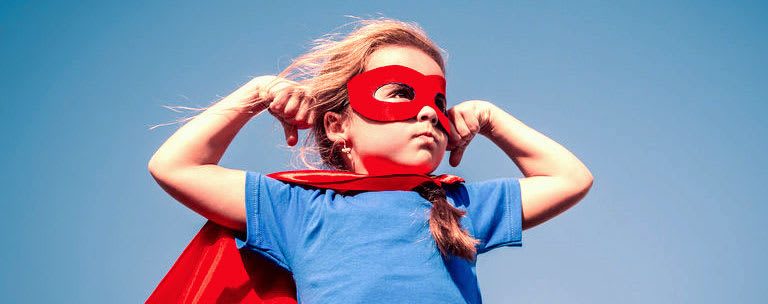 A confident child in a superhero pose